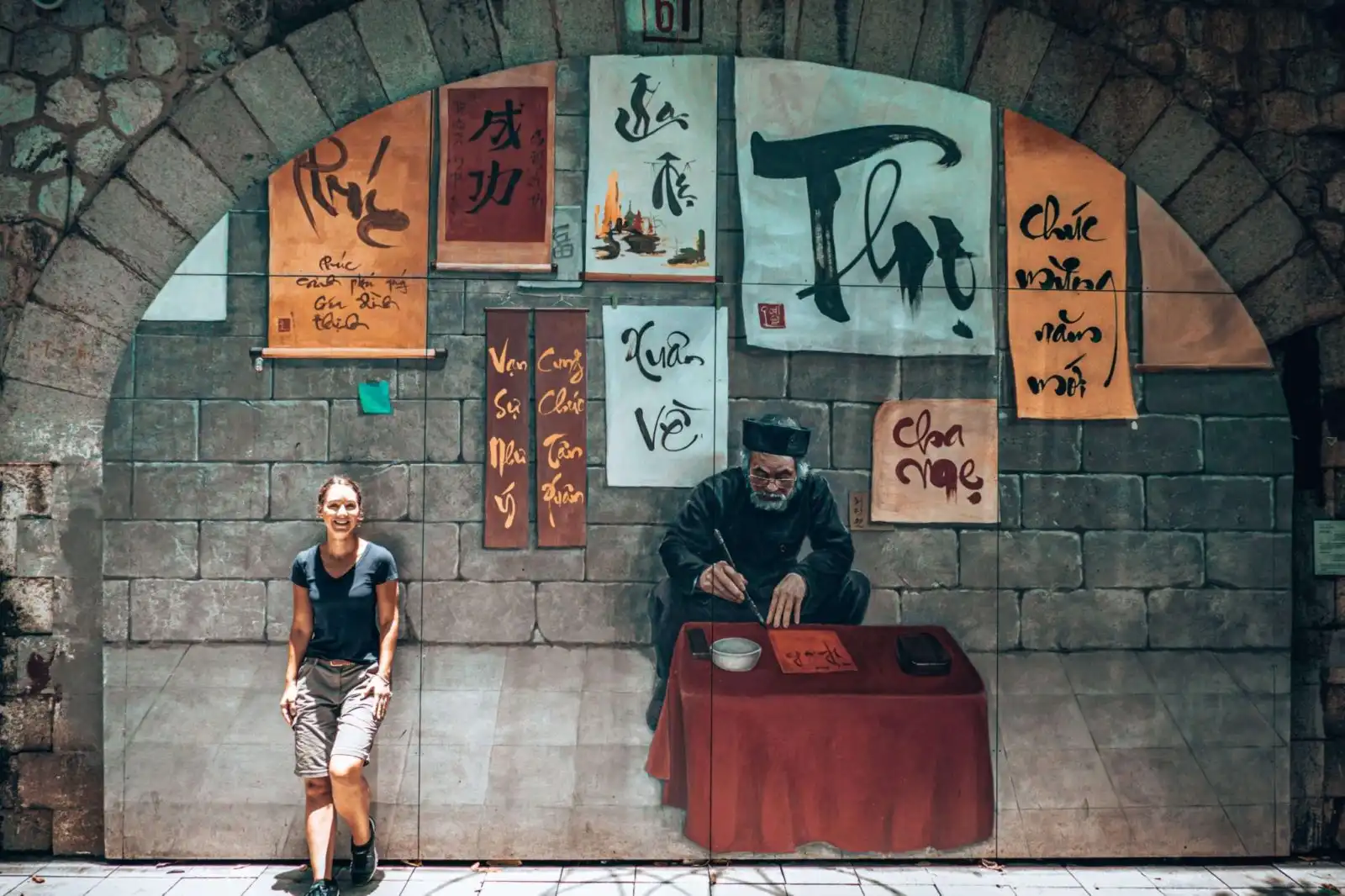 Girl standing in front of mural wall in Hanoi Vietnam