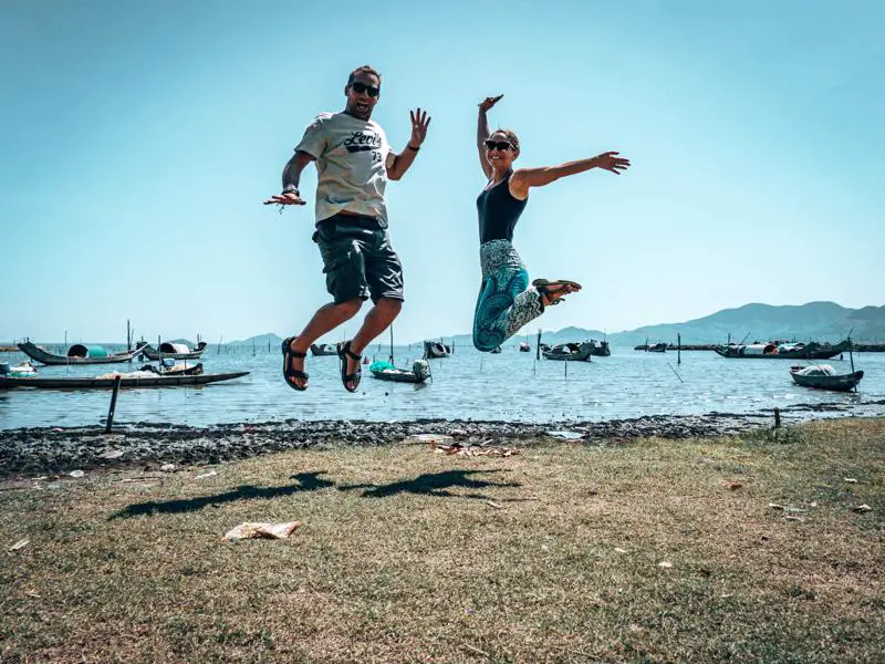 Lee and James jumping in front of lagoon on Hue to Hoi An bike ride